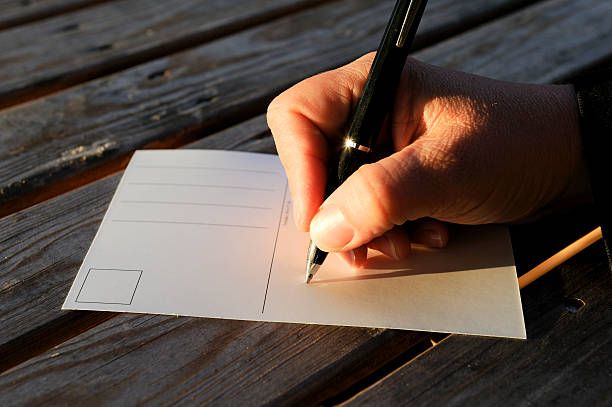 Person signing a postcard